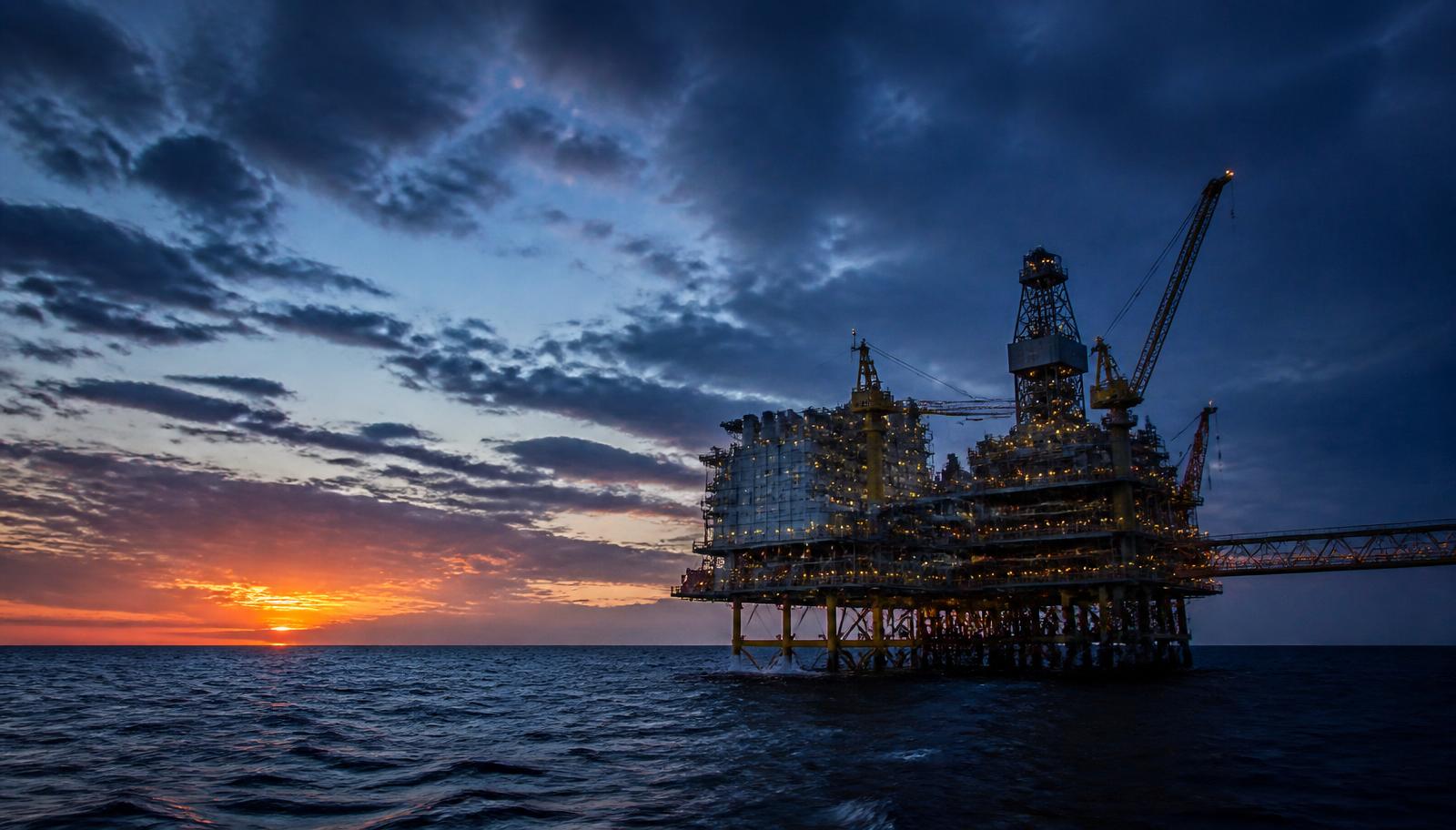Offshore oil and gas platform at sunset